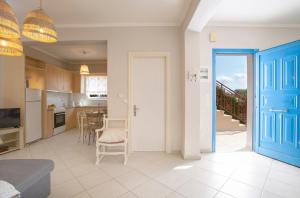 a kitchen and dining room with a blue door at Levanda Cozy Apartments in Lefkada