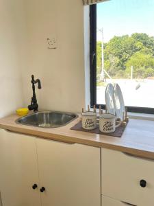 a kitchen counter with a sink and a window at Tiny House & Pool 4 pax 3 mins Merang Jetty in Setiu