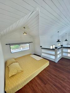 una camera da letto con letto giallo in una stanza bianca di Memerang Tiny House & Pool 4 pax Merang a Setiu