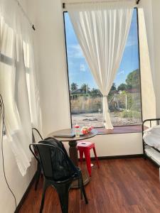 a room with a window with a table and a chair at Tiny House & Pool 4 pax 3 mins Merang Jetty in Setiu