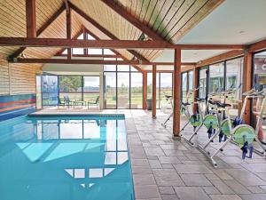 a gym with a swimming pool and chairs in a building at Les Gîtes du Pêcheur in Erquy