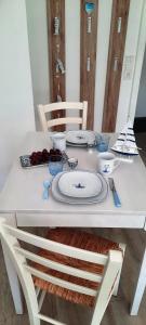 a white table with plates and utensils on it at Haus Panorama - Kleines Sternchen in Grömitz