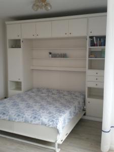 a bedroom with a white bed and shelves at Haus Panorama - Kleines Sternchen in Grömitz