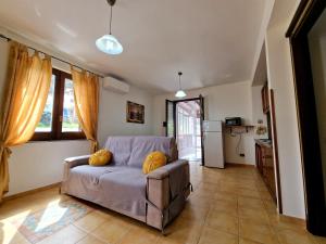 uma sala de estar com um sofá e uma cozinha em Rosa's house em Lipari