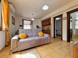 uma sala de estar com um sofá com almofadas amarelas em Rosa's house em Lipari