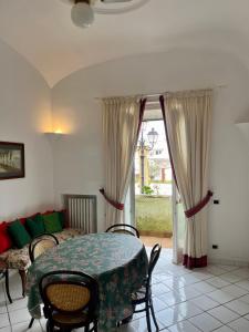 Habitación con mesa, sillas y ventana en House via Orlandi for 5 people, en Anacapri