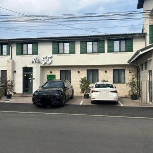 dos autos estacionados en un estacionamiento frente a un edificio en No. 55 en Buzau