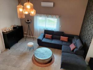 a living room with a blue couch and a table at Cosy Casa in Saint-Romain-sur-Cher