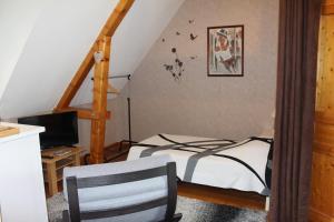 a bedroom with a bed and a desk with a chair at B&B DeValpierre adult only in Glanville