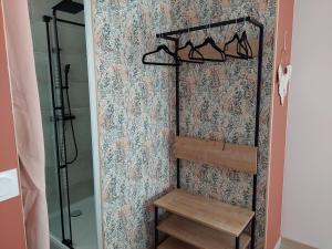 a walk in shower with a bench and a wall at Cosy Casa in Saint-Romain-sur-Cher