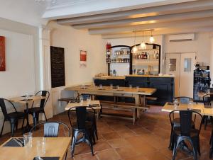 un restaurante con mesas y sillas y un bar en LE PATIO, en Grignan