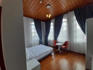 a bedroom with a bed and a table and windows at VE HOTELS KAPADOKYA in Nevşehir