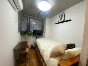 a bedroom with a bed and a desk and a television at 民泊BNB-秋葉原や浅草が徒歩圏内です-（1～2名）無料WiFi in Tokyo