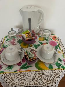 una mesa con dos platos y un hervidor de agua. en B&B Relax, en Miane