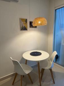 a white table with two chairs and a lamp at The Shore 22, Kota Kinabalu by HypnosSuites in Kota Kinabalu