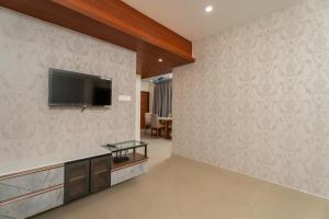 een woonkamer met een flatscreen-tv aan de muur bij Lumiere Premium Apartments in Trivandrum