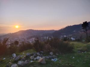 a sunset on top of a hill with rocks at Seven Endue Delight with Mountain view on the Hill Top in Ooty