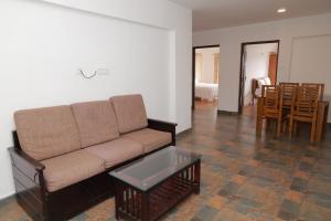 a living room with a couch and a table at Seven Endue Delight with Mountain view on the Hill Top in Ooty