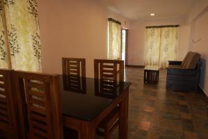 a living room with four chairs and a table at Seven Endue Delight with Mountain view on the Hill Top in Ooty