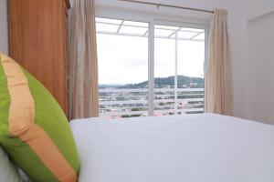 a bedroom with a bed and a large window at Seven Endue Delight with Mountain view on the Hill Top in Ooty