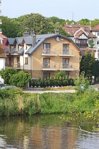 un gran edificio junto a una masa de agua en Villa Kapitańska en Kołobrzeg