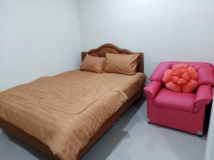 uma cama e uma cadeira num quarto em Nopphadon Hotel em Lat Krabang