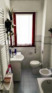 a bathroom with a sink and a toilet and a window at Grattacielo Apartment in Rapallo