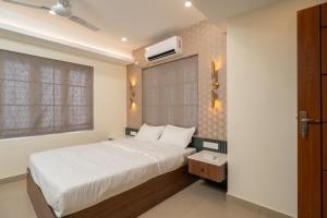 een slaapkamer met een wit bed en een raam bij Lumiere Premium Apartments in Trivandrum