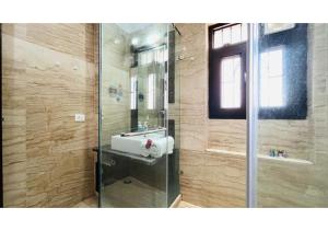 a bathroom with a sink and a glass shower at BluO Studio - M Block Mkt Greater Kailash in New Delhi