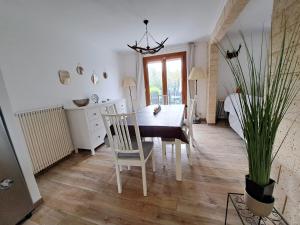 une salle à manger avec une table et des chaises dans l'établissement L'écureuil parisien Maison de charme avec jardin proche Paris, à Cormeilles-en-Parisis
