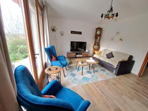 sala de estar con sillas azules y sofá en L'écureuil parisien Maison de charme avec jardin proche Paris, en Cormeilles-en-Parisis