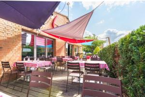 un restaurant avec des tables et des chaises sur une terrasse dans l'établissement Campanile Lille Est - Villeneuve D'ascq, à Villeneuve d'Ascq