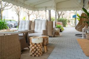 un patio al aire libre con mesas y sillas de mimbre en Hotel Olimpia, en Forte dei Marmi
