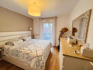Schlafzimmer mit einem Bett, einem Spiegel und einem Schreibtisch in der Unterkunft JO Paris 2024 in Saint-Ouen
