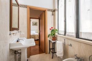 een badkamer met een wastafel, een toilet en een raam bij Secret Garden Siena in Siena