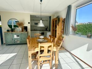 uma cozinha e sala de jantar com uma mesa de madeira e cadeiras em Bohemien Resort 46 em Sint Maartensvlotbrug