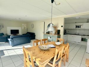 uma cozinha e sala de estar com uma mesa de madeira e cadeiras em Bohemien Resort 46 em Sint Maartensvlotbrug