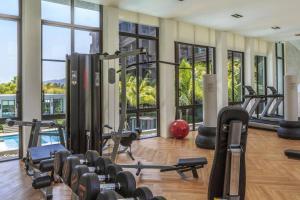 ein Fitnessstudio mit vielen Trainingsgeräten und Fenstern in der Unterkunft Luxury King Bed Apartment with Pool View and Sauna in Rawai Beach