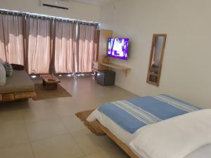 1 dormitorio con 1 cama y TV de pantalla plana en Villas Rocher - Junior Suite 2C en Grand Baie