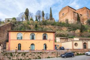 un viejo edificio al lado de una colina en Secret Garden Siena, en Siena