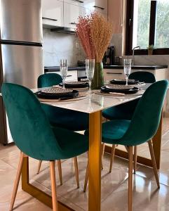 a dining room table with green chairs in a kitchen at Mons Apartments in Spílion