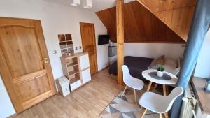 a small room with a table and chairs and a staircase at O.W. MEGA nad jeziorem in Żywiec