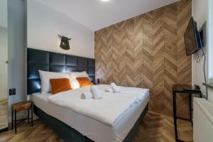 1 dormitorio con 1 cama blanca grande con almohadas de color naranja en Apartament Agat H2 z prywatną SAUNĄ - Mountain Aparts, en Świeradów-Zdrój