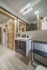 y baño con lavabo blanco y espejo. en Apartament Agat H2 z prywatną SAUNĄ - Mountain Aparts, en Świeradów-Zdrój