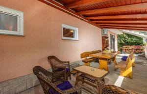 a patio with wicker chairs and tables and a table at Apartman Nora in Mučići