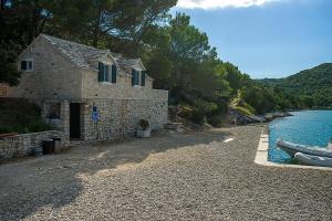 a building next to a body of water with a boat at House Ana in Pučišća