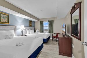 a hotel room with two beds and a television at Atlantica Resort Condo Oceanfront Close to the beach in Myrtle Beach