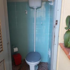 a bathroom with a blue toilet in a blue tiled room at Casa no centro de Saquarema in Saquarema