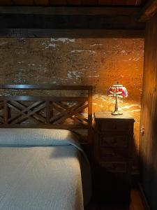 um quarto com uma cama e um candeeiro numa cómoda em Casa rural en Redes em Ríoseco
