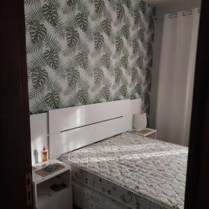 a small bedroom with a bed with a wall at Casa no centro de Saquarema in Saquarema